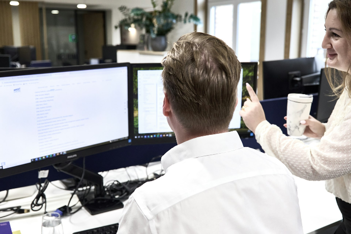 Two colleagues collaborating at office computers